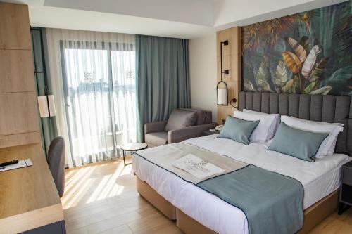 a hotel room with a large bed and a couch at Side Zeugma Hotel - Adult Only 16 Plus in Side