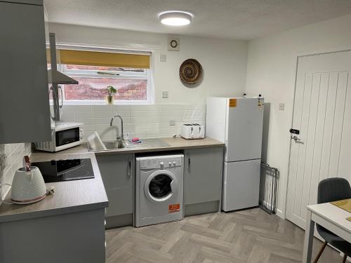 eine Küche mit einer Waschmaschine und einem Kühlschrank in der Unterkunft The Uxbridge Suite in Hednesford