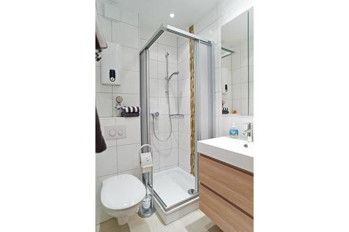 ein Bad mit einer Dusche, einem WC und einem Waschbecken in der Unterkunft Haus Bielefeld Appartement 24 in Norderney