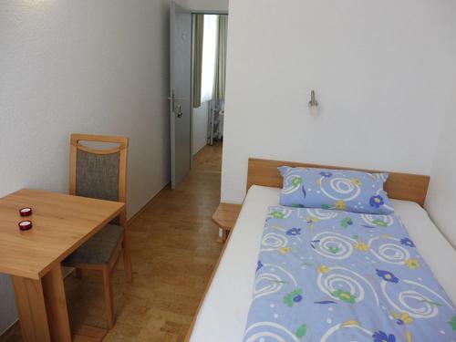 a room with a bed and a table and a table and a bed at Haus Bielefeld Zimmer 25a in Norderney