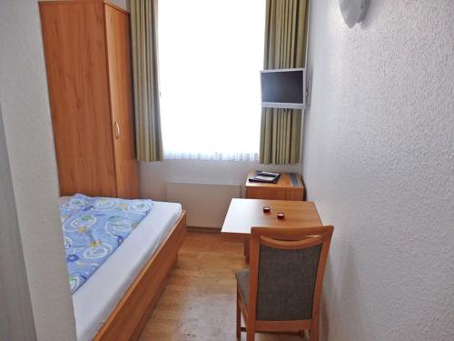 a small room with a bed and a table at Haus Bielefeld Zimmer 25a in Norderney