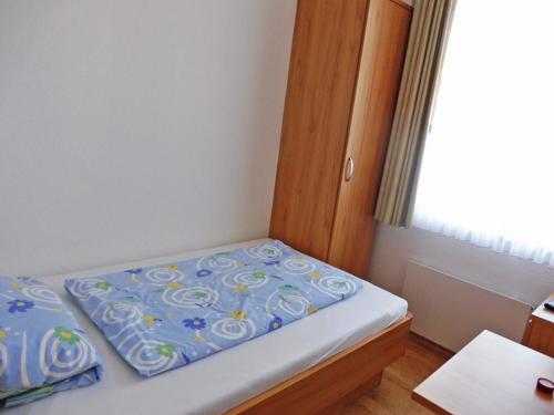 a small bedroom with a bed with a blue comforter at Haus Bielefeld Zimmer 25a in Norderney