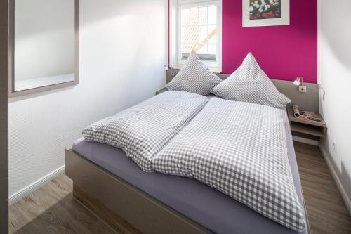 - une chambre avec un lit doté de draps et d'oreillers blancs dans l'établissement Haus Bielefeld Ferienwohnung 14, à Norderney