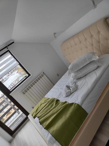 a bedroom with a bed with a green blanket at VILA RAISA in Neagra Şarului