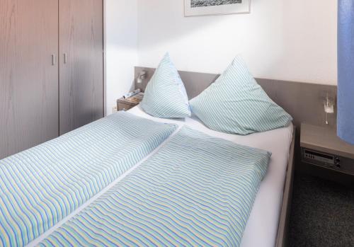 1 dormitorio con 2 camas y almohadas azules y blancas en Haus Bielefeld Ferienwohnung 13, en Norderney