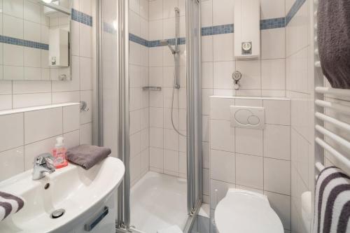 ein Bad mit einer Dusche, einem WC und einem Waschbecken in der Unterkunft Haus Bielefeld Ferienwohnung 12 in Norderney