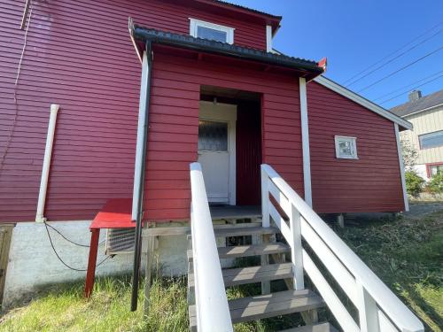 a red house with a staircase leading to a door at Edith Huset in Moskenes