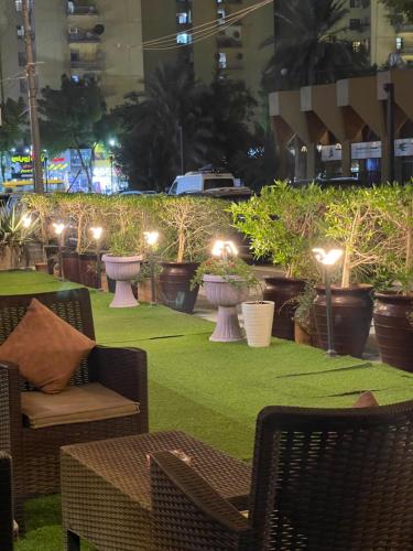 a patio with chairs and plants and lights at Al-Rabie Hotel & Apartments in Baghdad