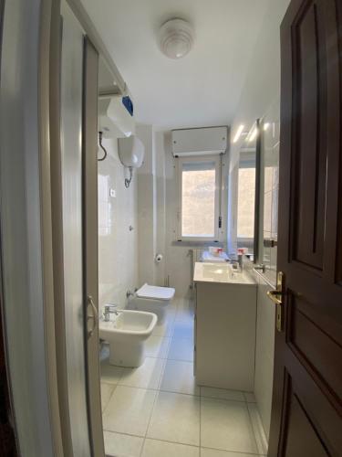Baño blanco con lavabo y aseo en Residence La Peonia en Sassari