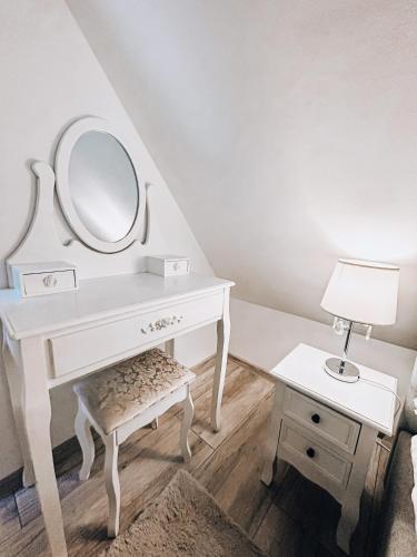 a white dressing table with a mirror and a stool at Parkowy Kudowa in Kudowa-Zdrój
