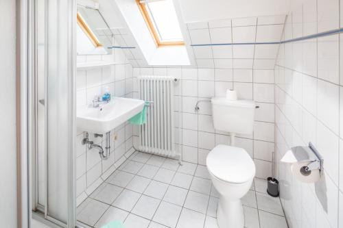 Baño blanco con aseo y lavamanos en Haus Coordes Wohnung 04, en Norderney