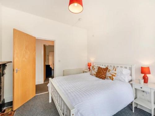 a bedroom with a large white bed and a door at Charles Alexander Short Stay - Clifton House Apartment in Lytham St Annes