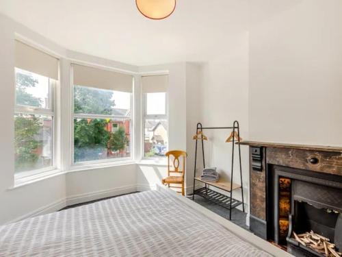a white room with a bed and a fireplace at Charles Alexander Short Stay - Clifton House Apartment in Lytham St Annes