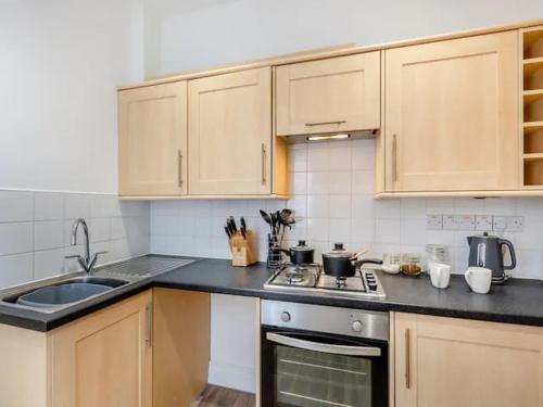 a kitchen with a sink and a stove top oven at Charles Alexander Short Stay - Clifton House Apartment in Lytham St Annes