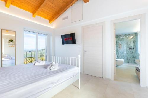 una camera bianca con letto e balcone di Ca'd Felice - Villa nella natura con vista Langhe a Rodello