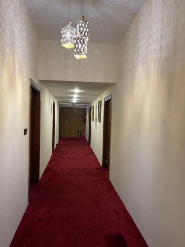 a long corridor with a red carpet in a hallway at Al-Rabie Hotel & Apartments in Baghdād