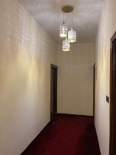an empty room with two lights and a red carpet at Al-Rabie Hotel & Apartments in Baghdad