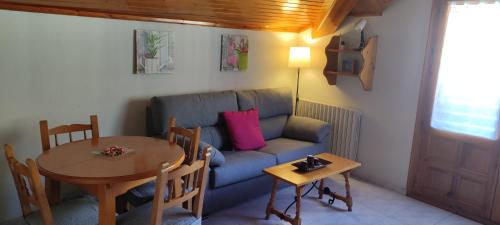 a living room with a blue couch and a table at Apartamentos Lausan in Gavín