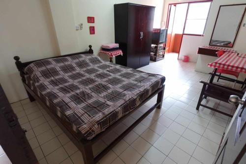 Un dormitorio con una cama con una manta a cuadros. en RTW Residence 557 en Bang O