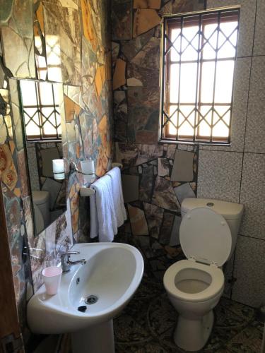 a bathroom with a toilet and a sink at Emakhabeleni Bed & Breakfast in Manguzi