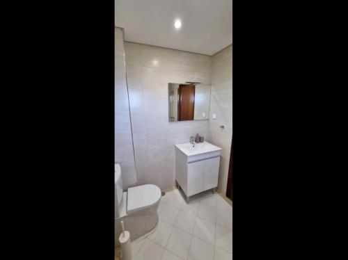 uma casa de banho com um WC branco e um lavatório. em New Cozy Apartment em Vilamoura
