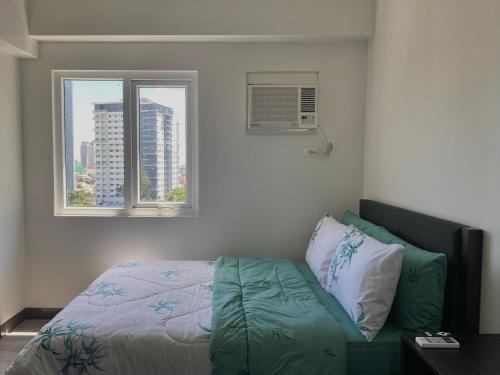 a bedroom with a bed and two windows at Condo • WIFI up to 100mbps • Pool • Netflix&Chill in Cebu City