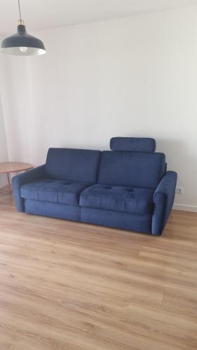 a blue couch in a living room with a wooden floor at WROCLOVE_NET APARTMENTS in Wrocław