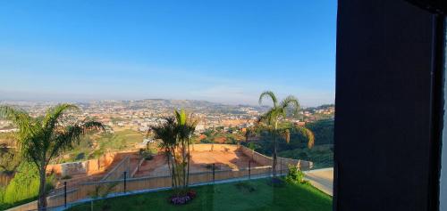 a view of a city from a building with palm trees at Villa Alexandra in Antananarivo