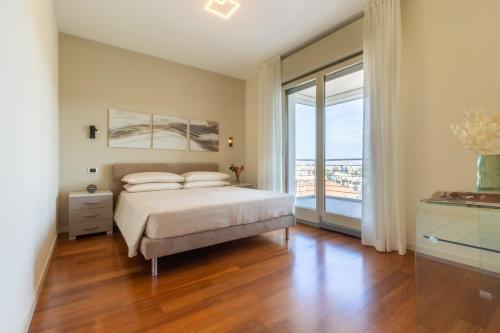 a bedroom with a bed and a large window at Terrazza61 - Appartamento con vista spettacolare sulla città di Cagliari in Cagliari