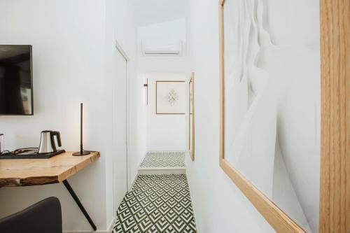 a hallway with white walls and a table and a desk at Boutique Suites 186 in Sorrento