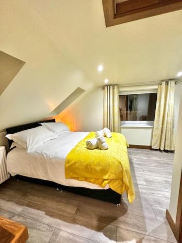sypialnia z dużym łóżkiem i żółtym kocem w obiekcie The Annex w mieście Dalbeattie