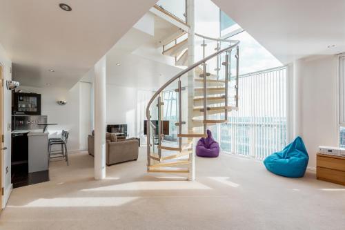 a living room with a spiral staircase and a kitchen at Premium Apartments By Excel in London