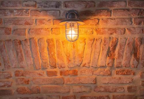 eine Leuchtvorrichtung, die an einer Ziegelwand hängt in der Unterkunft Stylish Duplex in Venetian Villa 