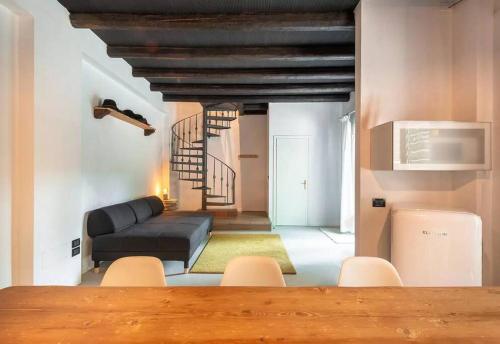 ein Wohnzimmer mit einem schwarzen Sofa und einer Treppe in der Unterkunft Stylish Duplex in Venetian Villa 