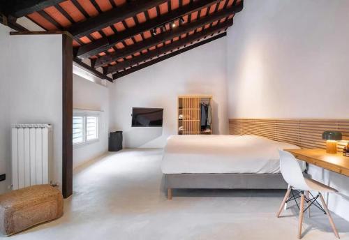 Schlafzimmer mit einem Bett, einem Tisch und einem Schreibtisch in der Unterkunft Stylish Duplex in Venetian Villa 