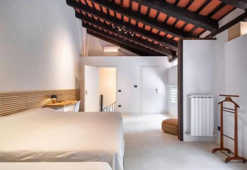 ein Schlafzimmer mit einem weißen Bett und einer Holzdecke in der Unterkunft Stylish Duplex in Venetian Villa 