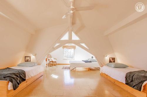 a attic bedroom with two beds and a ceiling fan at Entre ciel & Loire in Saint-Agnan-sur-Loire