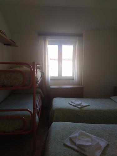 ein kleines Zimmer mit 2 Betten und einem Fenster in der Unterkunft Da Teresa in Bardineto