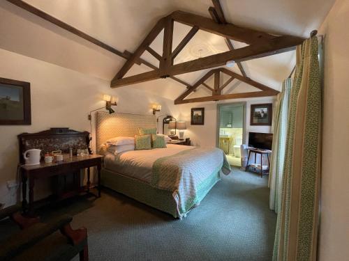 a bedroom with a large bed in a room with beams at The Durham Ox in Crayke