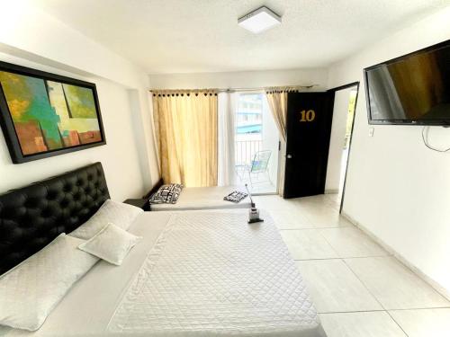 um quarto de hotel com uma cama e uma televisão em Hotel Tradicional Villeta em Villeta