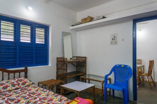 una camera con un letto, un tavolo e una sedia blu di Sweet Spot a Pondicherry