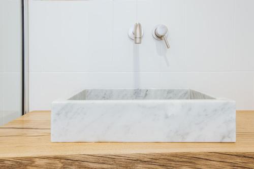 a white marble sink in a white bathroom at Boutique Suites 186 in Sorrento
