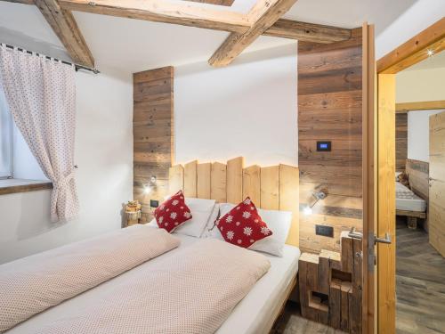 Schlafzimmer mit einem weißen Bett und roten Kissen in der Unterkunft CESA MARIN in Campitello di Fassa