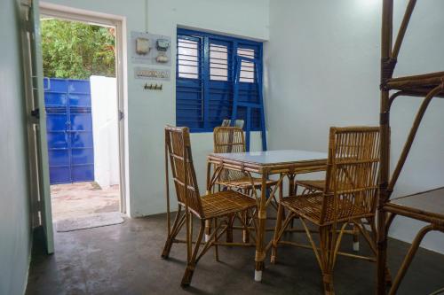 una sala da pranzo con tavolo, sedie e porta di Sweet Spot a Pondicherry