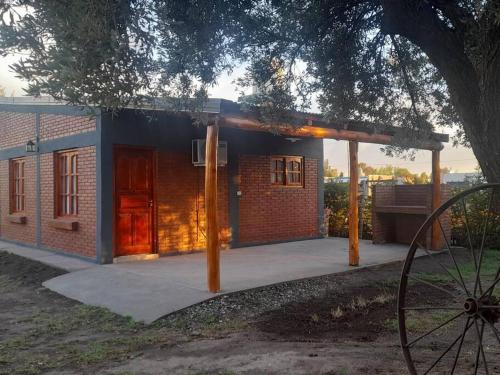 ein kleines Backsteinhaus mit einer roten Tür in der Unterkunft cabañas oliv- san rafael-mendoza in San Rafael