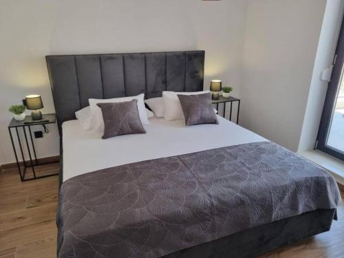 a bedroom with a large bed with white sheets and pillows at Apartment Terezija in Dubrovnik