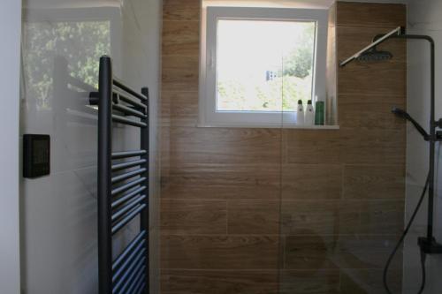 a bathroom with a glass shower with a window at Apartment Terezija in Dubrovnik