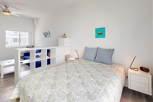 a bedroom with a white bed and a white dresser at Sea Grape Getaway in Marathon