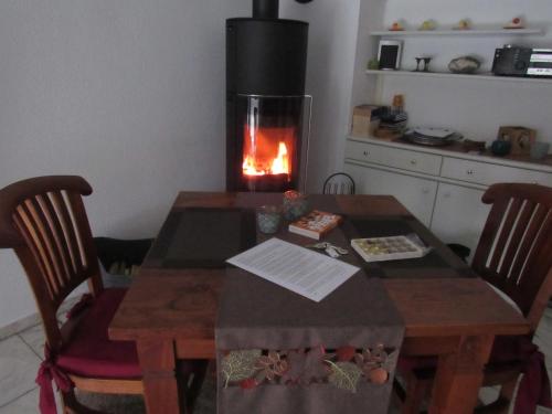 a table and chairs with a fireplace in a kitchen at Wohnung für Liebhaber - gerne auch mit Kindern in Sundern