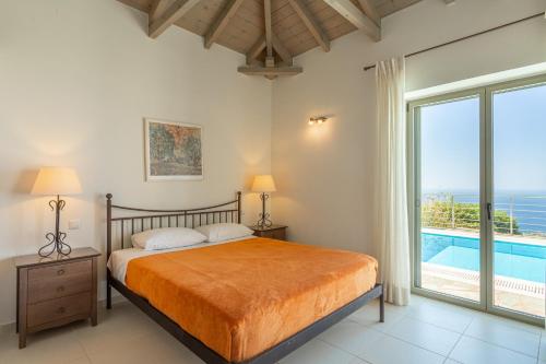 a bedroom with a bed and a large window at PHAEDRA, Luxury Villa Private Infinity Pool Sea View Stoupa in Exochori